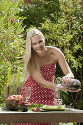 Austria, Woman pouring wine in glass, smiling - HHF03189