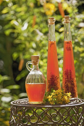 Austria, Salzburger Land, St. John's wort oil in bottle on table - HHF03159