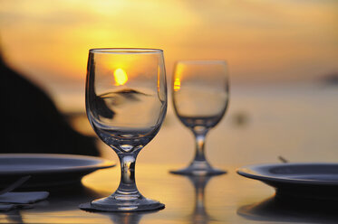 Wine glasses on table at sunset, close-up - GNF01181