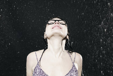 Woman enjoying in rain, smiling. - FMKF00076
