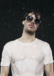 Man standing in rain, wearing sunglasses. - FMKF00027