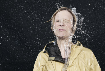 Woman enjoying splash of water, eyes closed. - FMKF00023