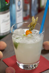 Lychee cocktail with slice of lime and rambutan, close up. - CHKF00960