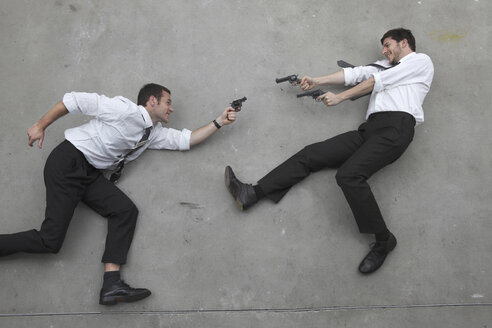 Two businessmen duelling with weapons, portrait, elevated view - BAEF00025