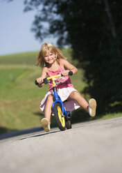 Österreich, Mondsee, Mädchen (4-5) beim Fahrradfahren, lächelnd, Porträt - WWF01265