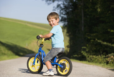 Österreich, Mondsee, Junge (2-3) beim Fahrradfahren, lächelnd, Porträt - WWF01262