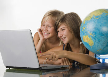 Two girls (10-11) using laptop, smiling - WWF01237