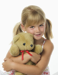 Mädchen (4-5), das einen Teddybären umarmt, lächelnd, Porträt - WWF01227