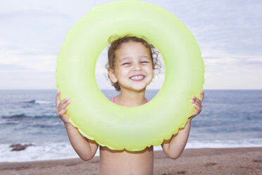 France, Corsica, Girl (2-3) looking through inner tube, smiling, portrait - SSF00056