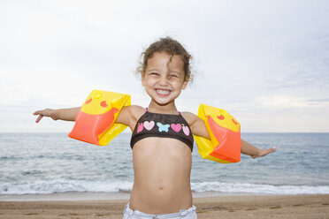 France, Corsica, Girl (2-3) wearing armbands on beach, smiling, portrait - SSF00055