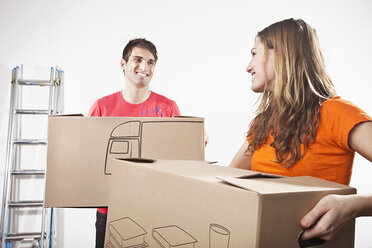 Young couple carrying cardboard boxes, smiling - SSF00037