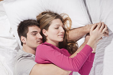 Junges Paar auf dem Bett liegend, Augen geschlossen - SSF00018