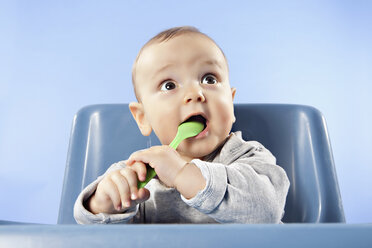 Baby boy playing (6-11 months) with spoon, looking away - SSF00003