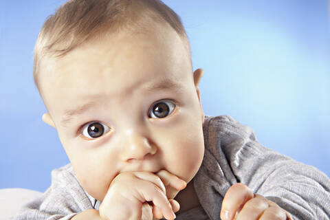 Baby-Junge (6-11 Monate) mit Finger im Mund, Nahaufnahme, Porträt, lizenzfreies Stockfoto