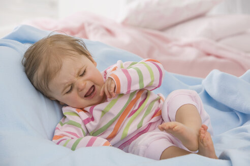 Baby-Mädchen (6-11 Monate) auf Decke liegend und weinend - SMOF00452