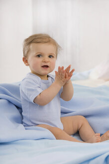 Baby girl (6-11 months) clapping hands, portrait - SMOF00423