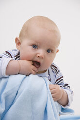 Baby boy (6-11 months) with finger in mouth, portrait - SMOF00416