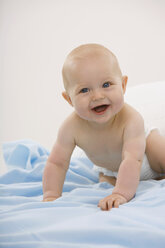 Baby boy (6-11 months) crawling, smiling, portrait - SMOF00402