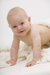Baby-Junge (6-11 Monate) krabbelnd, lächelnd, Porträt - SMOF00396