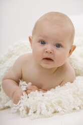 Baby boy (6-11 months) lying on bed, portrait - SMOF00395