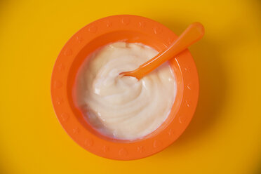 Baby food in bowl on yellow background, close-up - SMOF00386