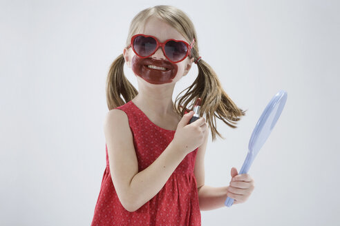 Mädchen (4-5) trägt eine Sonnenbrille und spielt mit Lippenstift - RBF00249