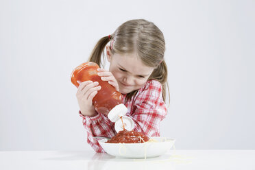 Mädchen (4-5) gießt Ketchup auf Spagetti - RBF00243