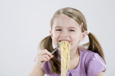 Mädchen (4-5) isst Spagetti, lächelnd, Porträt - RBF00240