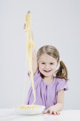 Mädchen (4-5) isst Spagetti, lächelnd, Porträt - RBF00237