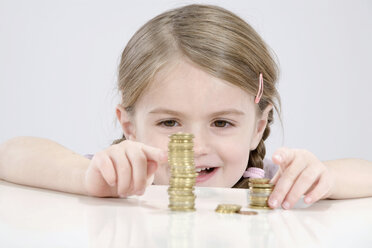 Girl (4-5) counting stack of coins - RBF00233