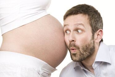 Mann hört dem Bauch einer schwangeren Frau zu, Nahaufnahme - RBF00215