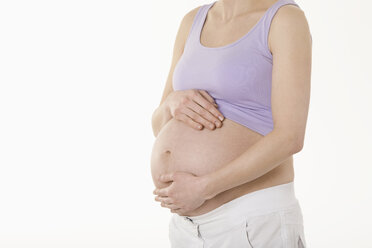 Schwangere Frau stehend mit Händen auf dem Bauch, Mittelteil - RBF00208