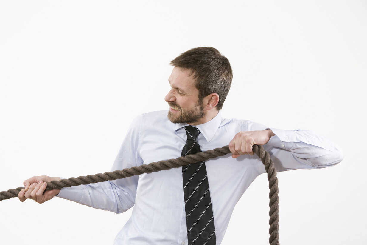 Businessman pulling rope stock photo