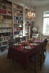 Place setting on dining table with bookshelf in background - NHF01210