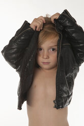 Junge (4-5) zieht Lederjacke aus, Porträt, Nahaufnahme - NHF01202