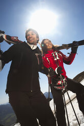 Italien, Südtirol, Paar trägt Ski, schaut weg, lächelt - KEF00010