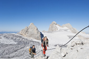 Österreich, Steiermark, Dachstein, Junges Paar beim Bergsteigen - HHF03336