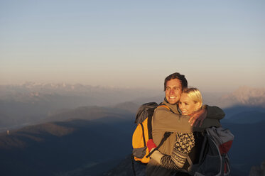 Österreich, Steiermark, Dachstein, Junges Paar umarmt sich auf Berggipfel, lächelnd - HHF03329