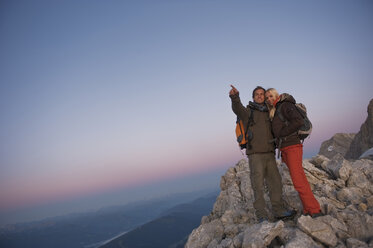 Österreich, Steiermark, Dachstein, Pärchen auf Berggipfel, Mann deutet weg - HHF03318