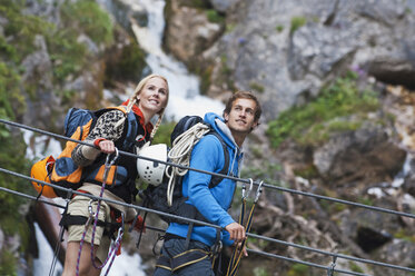 Austria, Steiermark, Ramsau, Silberkarklamm, Young couple walking on rope, looking away - HHF03295