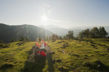Junges Paar, das auf einem Berggipfel eine Karte betrachtet. - HHF03233