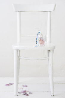 Sugared rose petals in glass on chair - COF00131