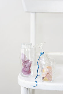 Sugared rose petals in glass on chair, close up - COF00130