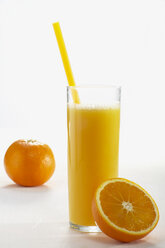 Frisch geschnittene und ganze Orangen und ein Glas Orangensaft - CHKF01049