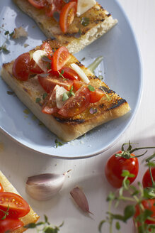 Ciabatta-Brot mit Tomaten- und Zwiebelscheiben im Teller. - CHKF01043