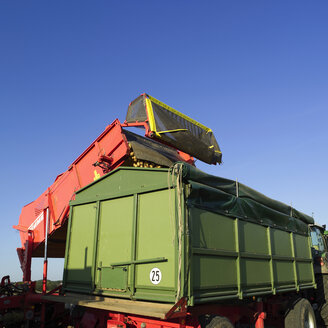 Deutschland, Hessen, Mähdrescher beim Verladen von Kartoffeln auf einen Lkw - AKF00157