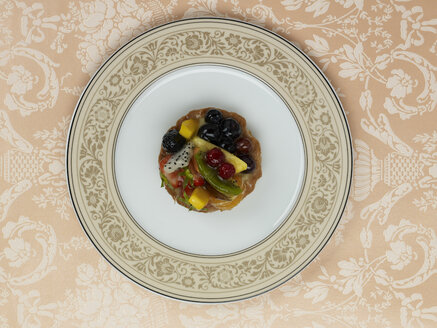 Obstkuchen im Teller vor gemustertem Hintergrund - AKF00135