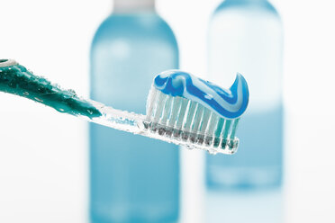 Nahaufnahme von Zahnbürste und Zahnpasta mit Mundwasserflasche im Hintergrund - 12305CS-U