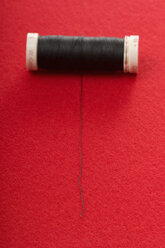 Black thread reel on red background - AWDF00512