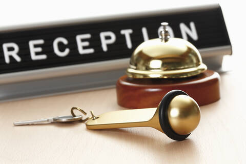 Reception sign with service bell and hotel key on desk stock photo